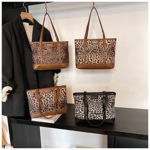 Detail of vintage leopard print tote bag featuring the leather fashion logo and sturdy handles