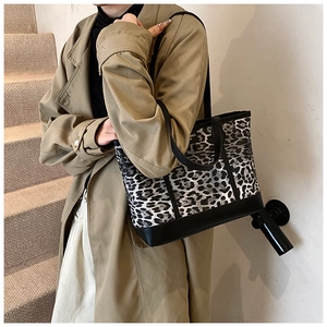 Detail of vintage leopard print tote bag with black leather straps and text label