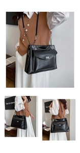 Detail view of black leather tote bag with silver metal twist lock and chain strap