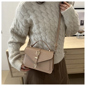 Khaki PU leather crossbody bag with envelope flap shown on model with beige sweater