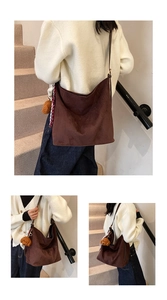 Detail of a brown suede hobo bag with a plush toy charm and vintage plaid ribbon