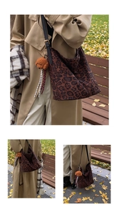 Detail of leopard print hobo bag with black leather strap and plush puppy charm
