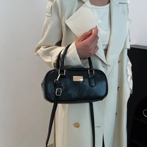 Elegante bolso Boston de cuero negro brillante con detalles metálicos dorados