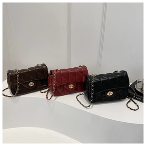 Close-up of quilted diamond pattern and golden chain straps on three color crossbody bags