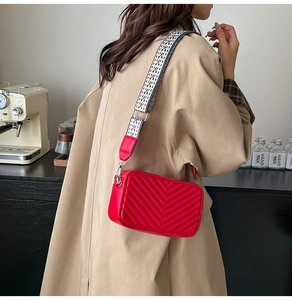 Détail du petit sac bandoulière rouge matelassé avec large sangle géométrique