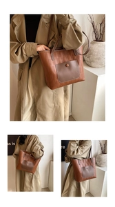 Detail of a brown woven tote bag featuring a contrasting dark pocket and long shoulder strap