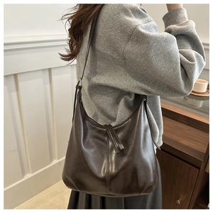 Detail of dark brown Hobo bag featuring glossy finish and long tassel zipper charms