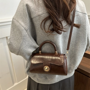 Vintage brown leather crossbody bag with golden rotary lock and top handle for women