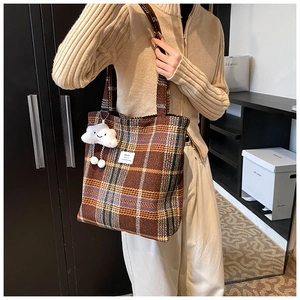 Detail of vintage brown plaid tote bag with soft fabric texture and cloud plush charm