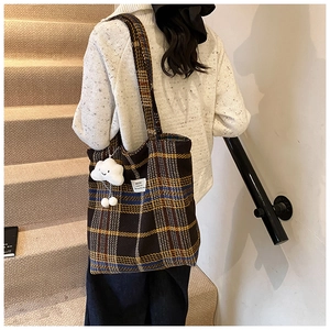 Detail of vintage plaid tote bag with plush cloud charm and sturdy shoulder straps