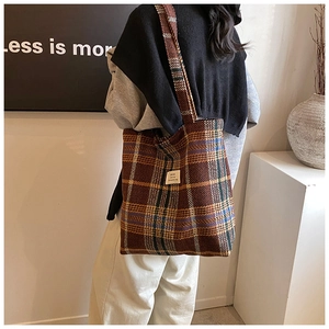 Classic orange plaid tote bag with logo tag shown on shoulder for autumn style