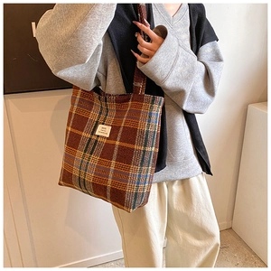 Close-up of retro plaid wool tote bag showing thick texture and woven brand label