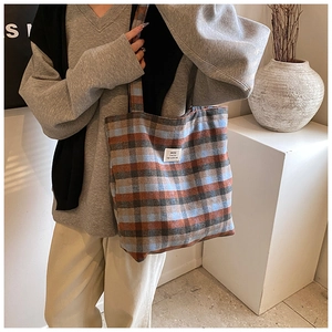 Detailed view of the vintage plaid canvas tote bag with stitched HOU high quality label