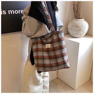 Detail of wool tote bag with blue and brown plaid pattern and stylish square patch