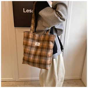 Detail of retro plaid tote bag showing soft wool fabric texture and brand label
