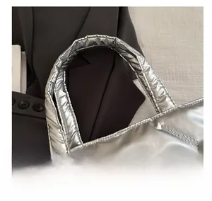Detail of metallic silver quilted tote bag showing padded handle and stitching texture