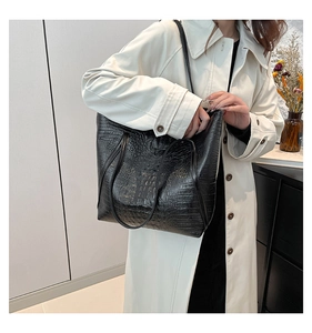 Detailed close-up of premium black crocodile pattern texture on a large tote bag