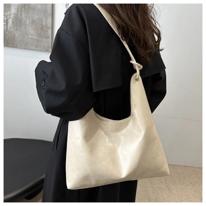 Vue latérale du sac fourre-tout en cuir PU beige montrant sa grande capacité et son design