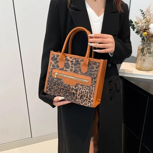 Chic leopard print tote bag with brown handles and front zipper detail in modern interior