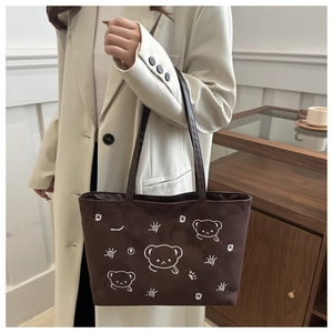 Detail of dark brown tote bag with white bear embroidery and comfortable shoulder strap