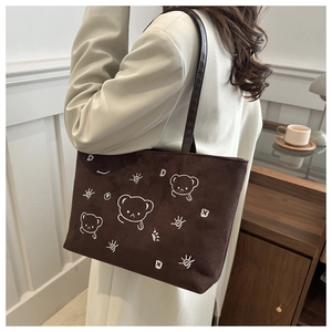 Detailed view of embroidery bear pattern on brown suede tote bag for students