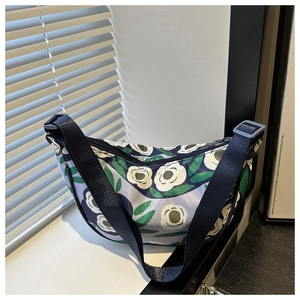 Detail of floral moon bag with adjustable navy strap and white camellia pattern