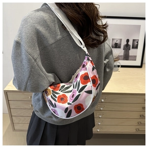 Detailed side view of floral hobo bag with adjustable strap worn by a female model