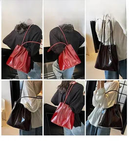 Model display of large glossy tote bag in red and brown colors for daily commuting use