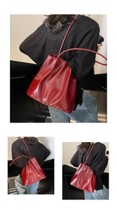 Detail shot of the glossy red patent leather surface with natural folds on a tote bag