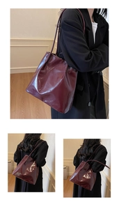 Detail view of burgundy glossy patent leather tote bag showing shoulder strap fit