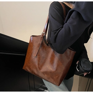Detail of adjustable silver buckle and vintage leather strap on brown tote bag