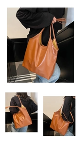 Macro view of brown leather tote bag with contrasting yellow lining and sleek straps