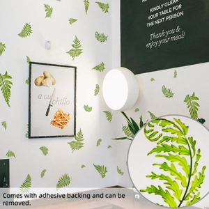 Détail du sticker mural feuille de fougère verte montrant sa texture autocollante amovible