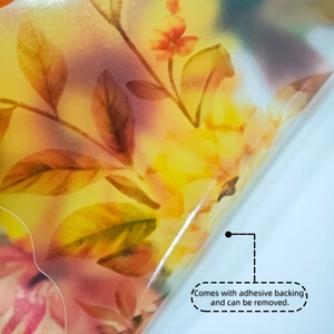 Detalle de vinilo decorativo floral translúcido con respaldo adhesivo despegado de la esquina