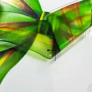 Detail of static cling window film showing colorful patterns on both sides in green and yellow