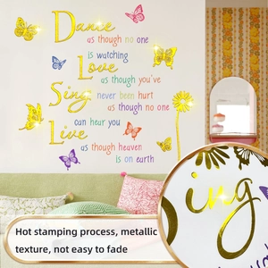 Détail macro des stickers muraux dorés avec citations inspirantes et des papillons