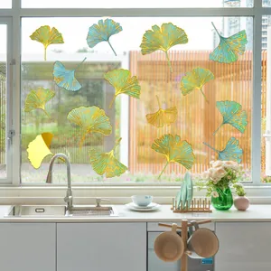 Detail of blue and green ginkgo leaf window decals with gold edges on bright glass