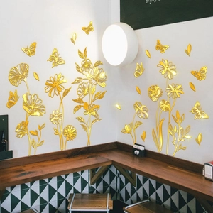 Detailed view of golden mirror flower and butterfly wall stickers on a modern white wall