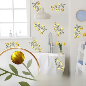 Detail of creative ginkgo leaf wall sticker with green leaves and gold mirrors in bathroom
