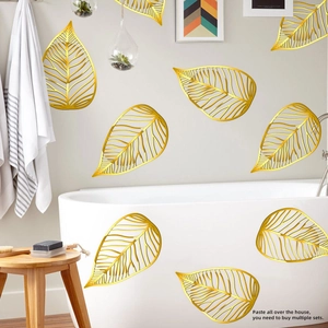 Detail of gold hollow leaf wall stickers set applied on minimalist bathroom tiles