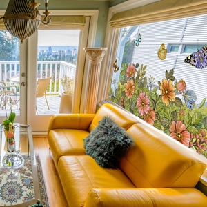 Vibrant pink floral and butterfly static window decals applied on glass in a sunny room