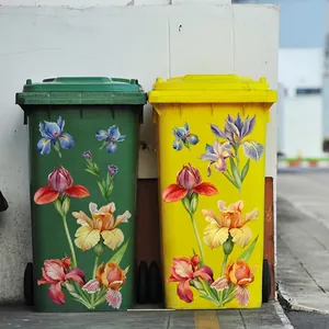 Floral iris decals on large green and yellow plastic rolling trash bins for home garden