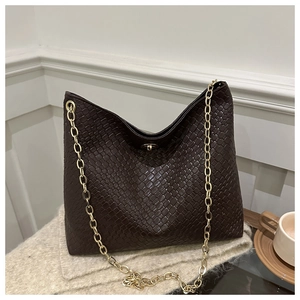 Vue détaillée de la texture en cuir tressé marron foncé avec bandoulière dorée