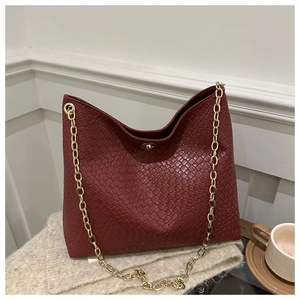 Détail d'un sac cabas bordeaux avec relief crocodile et fermoir en métal doré