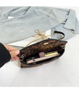 Detailed internal view of leopard print clutch showing phone and lipstick storage
