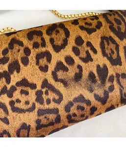 Close-up of leopard print faux suede fabric with elegant gold metal chain detail