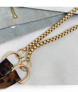 Detail of elegant gold chain strap with circular metal loops and leopard print fabric strap