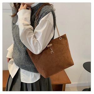 Brown suede shoulder bag with gold chain strap and reindeer metal charm details