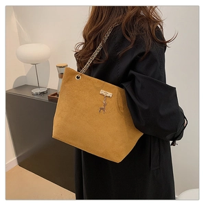 Brown suede tote bag featuring a gold chain strap and a metallic deer charm detail
