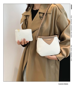 Détail d'un sac bandoulière blanc en cuir grainé avec rabat marron et petite pochette
